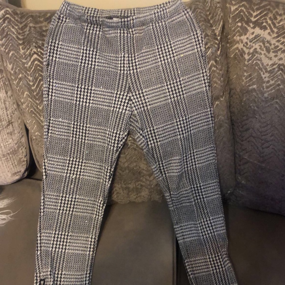 Black and white Checkered pants with zippers on the side of pants legs.